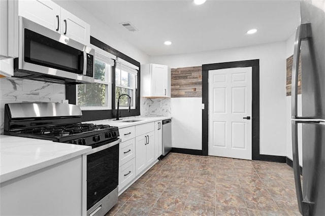 kitchen featuring visible vents, appliances with stainless steel finishes, light countertops, and a sink