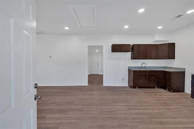 kitchen with dark brown cabinetry, sink, and light hardwood / wood-style floors