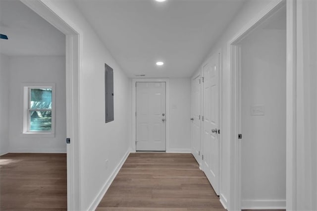 hallway featuring electric panel and light hardwood / wood-style floors