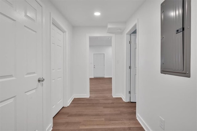 hallway with electric panel and hardwood / wood-style flooring