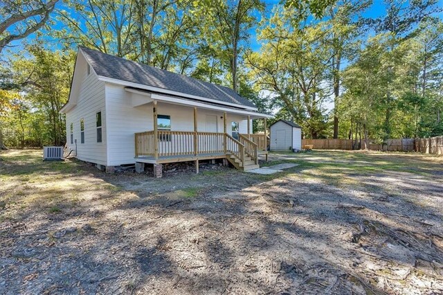 5361 N Main St, Acworth, GA 30101 - rear view of house featuring central AC, a shingled roof, fence, a storage unit, and an outbuilding