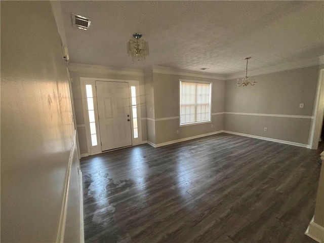 foyer with a chandelier, a textured ceiling, visible vents, ornamental molding, and dark wood finished floors