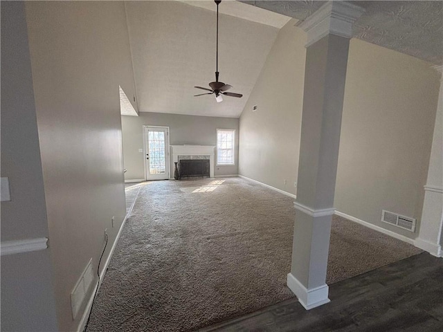 unfurnished living room with ornate columns, high vaulted ceiling, dark carpet, ceiling fan, and a high end fireplace