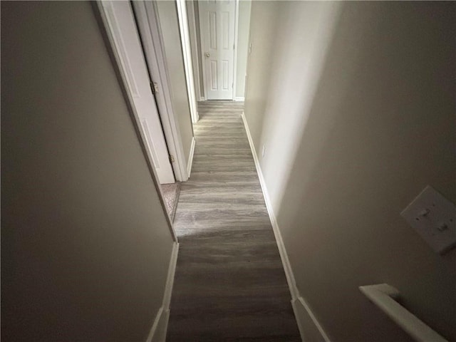 corridor with wood finished floors and baseboards