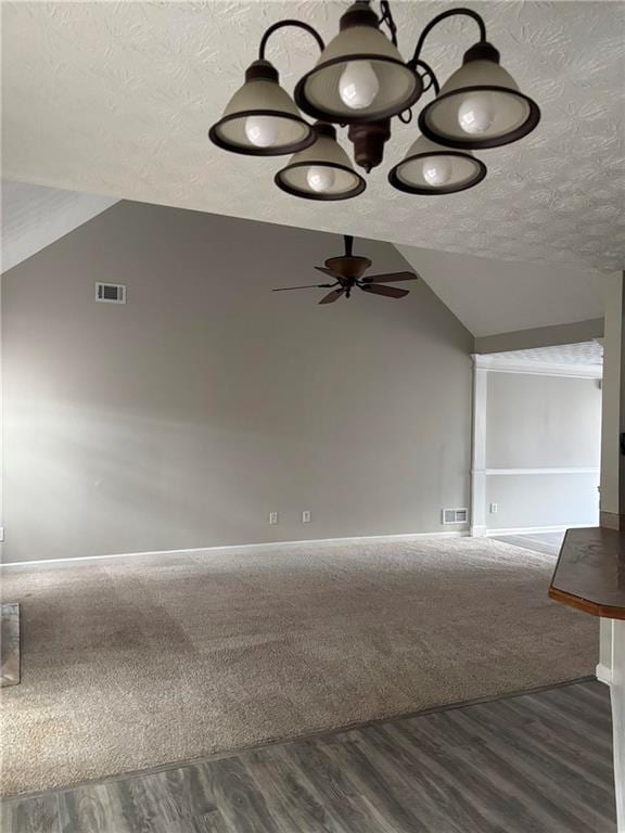 interior space featuring visible vents, vaulted ceiling, a textured ceiling, and wood finished floors