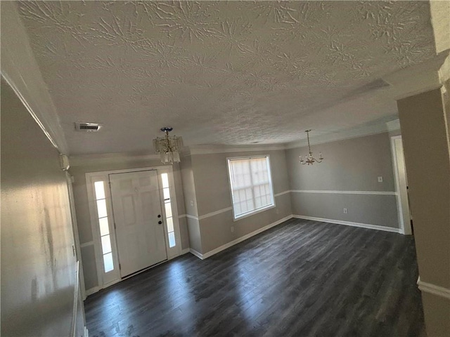 entryway featuring a textured ceiling, a notable chandelier, and dark hardwood / wood-style flooring