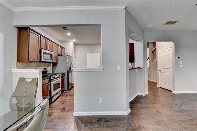 3351 Vintage Cir SE, Smyrna, GA 30080 - kitchen with appliances with stainless steel finishes, wood finished floors, tasteful backsplash, baseboards, and brown cabinetry