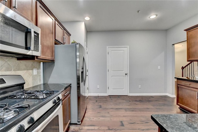 3351 Vintage Cir SE, Smyrna, GA 30080 - kitchen featuring appliances with stainless steel finishes, dark wood-style floors, decorative backsplash, dark stone countertops, and recessed lighting