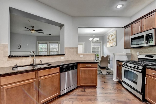 3351 Vintage Cir SE, Smyrna, GA 30080 - kitchen with stainless steel appliances, a sink, backsplash, wood finished floors, and dark stone counters