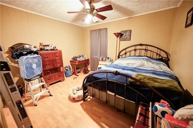 bedroom featuring a ceiling fan, crown molding, wood finished floors, and a textured ceiling