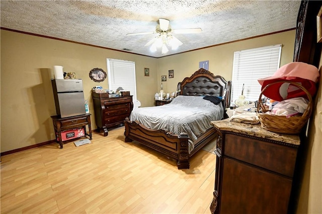 bedroom featuring a textured ceiling, ornamental molding, and light wood finished floors