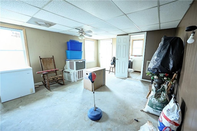 interior space featuring a drop ceiling and unfinished concrete flooring