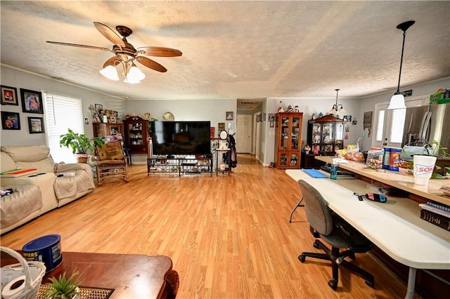 living area featuring a textured ceiling, ceiling fan, and light wood finished floors