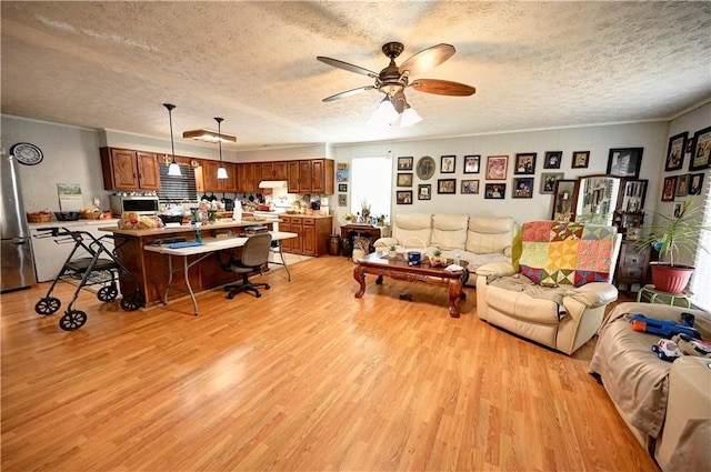 living room with a textured ceiling, a ceiling fan, light wood-style floors, and ornamental molding