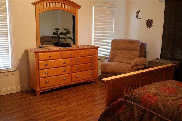 bedroom with dark wood-type flooring and baseboards