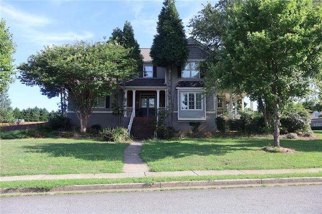 view of property hidden behind natural elements with a front lawn
