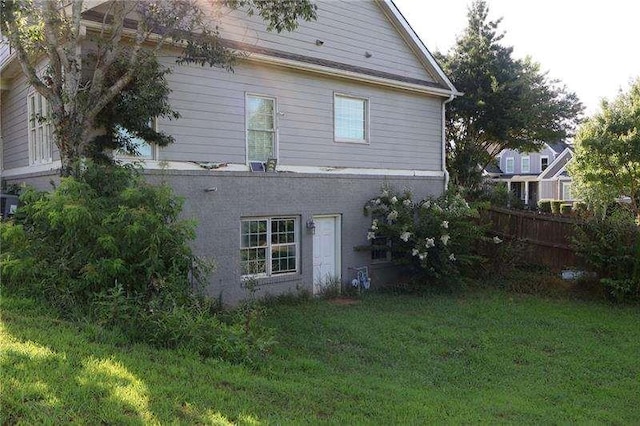 back of property with fence and a yard