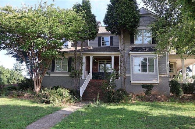 traditional home featuring covered porch, stairs, and a front lawn
