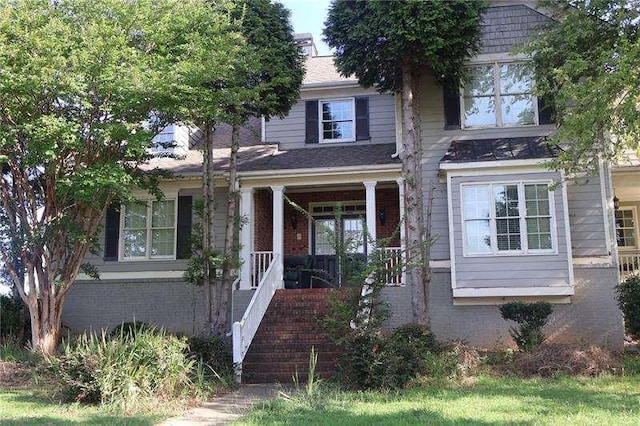 view of front of home with covered porch and brick siding
