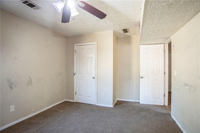 unfurnished bedroom featuring a textured ceiling, carpet flooring, and visible vents