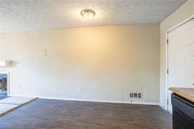 unfurnished living room with a textured ceiling, a fireplace, visible vents, and dark wood-style flooring