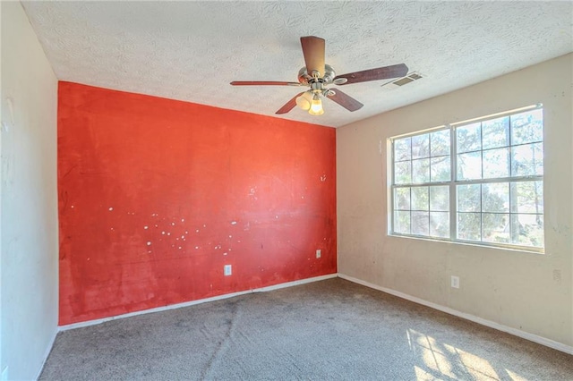 spare room featuring visible vents, ceiling fan, a textured ceiling, and baseboards