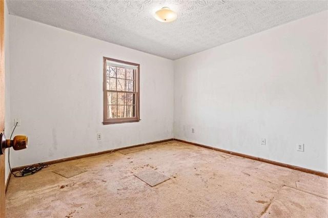 empty room with a textured ceiling and carpet floors