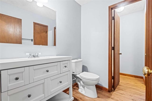 bathroom with vanity, hardwood / wood-style flooring, and toilet