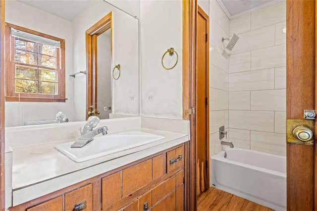 bathroom featuring vanity, wood-type flooring, and tiled shower / bath