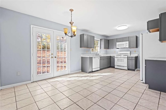 kitchen with a wealth of natural light, sink, hanging light fixtures, and white appliances