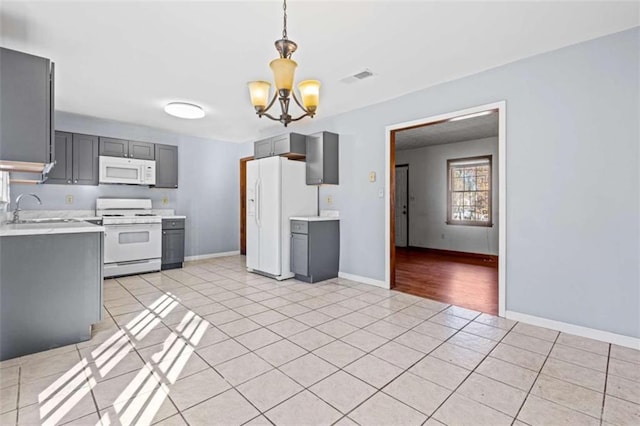 kitchen featuring pendant lighting, white appliances, sink, gray cabinets, and a chandelier