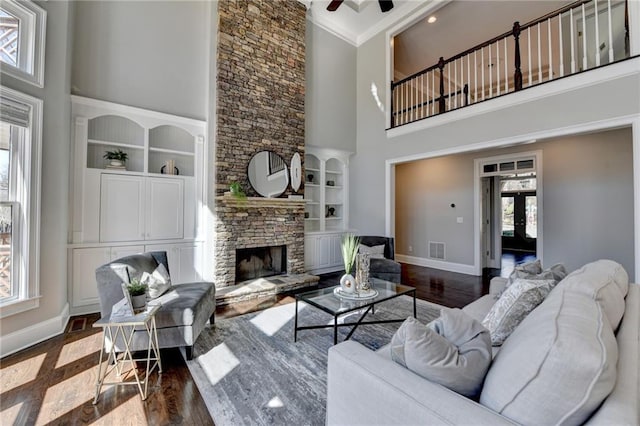 living area featuring a fireplace, wood finished floors, built in features, and baseboards