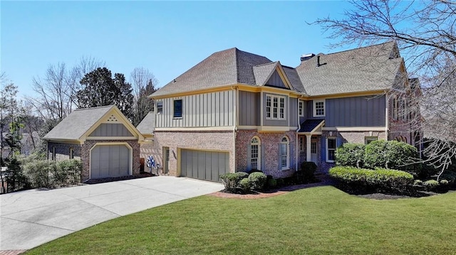 view of front of property featuring an attached garage, brick siding, concrete driveway, a front lawn, and board and batten siding