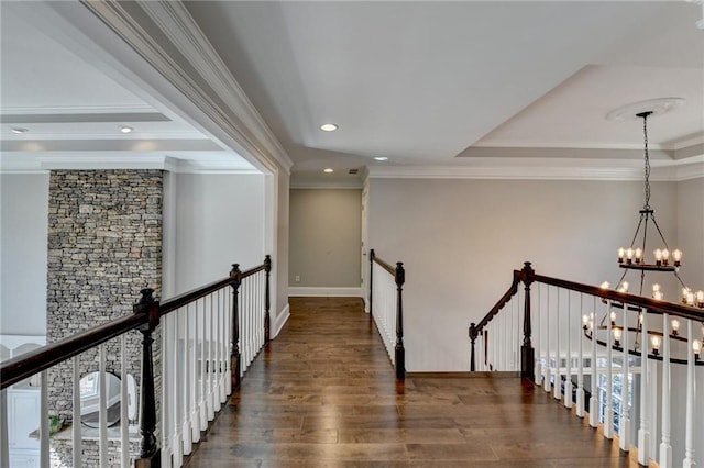 hallway with wood finished floors, crown molding, an upstairs landing, a chandelier, and recessed lighting