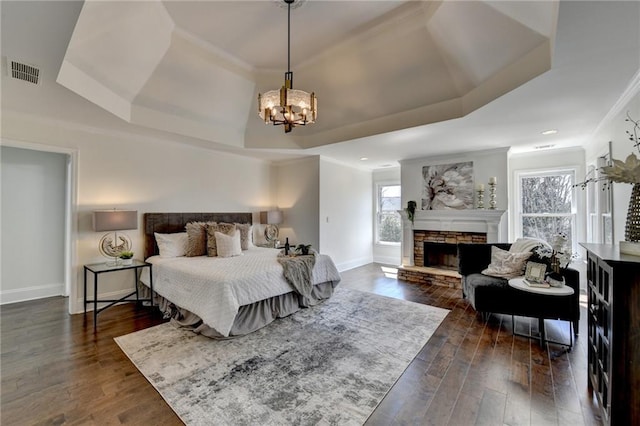 bedroom with visible vents, a raised ceiling, and dark wood finished floors