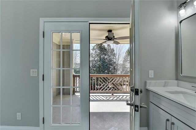 doorway with ceiling fan and a sink