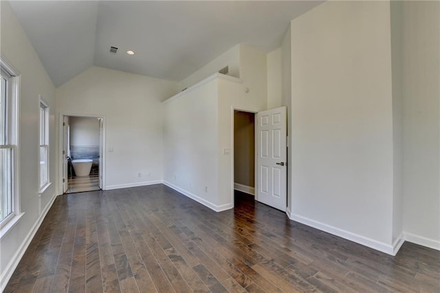 spare room featuring dark wood-style floors, high vaulted ceiling, visible vents, and baseboards