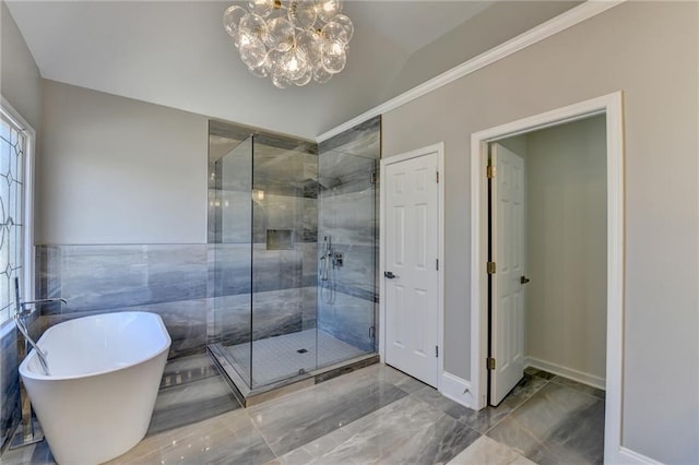 full bath featuring marble finish floor, lofted ceiling, a shower stall, a chandelier, and a freestanding tub