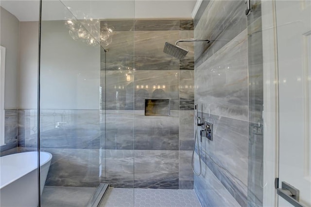 bathroom featuring a freestanding bath and a shower stall