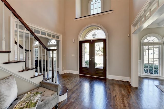 entrance foyer with french doors, plenty of natural light, wood finished floors, and baseboards