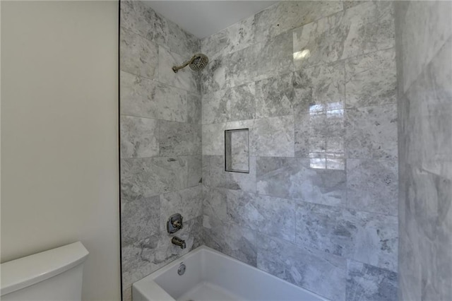 bathroom with bathtub / shower combination and toilet