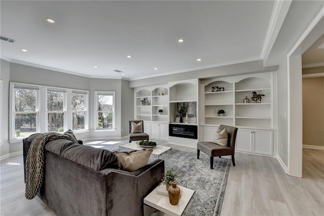 living area with a glass covered fireplace, baseboards, visible vents, and light wood finished floors