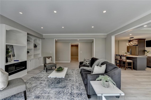 living area featuring ornamental molding, recessed lighting, light wood-style flooring, and built in shelves