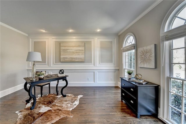 sitting room featuring baseboards, ornamental molding, a decorative wall, and dark wood-type flooring