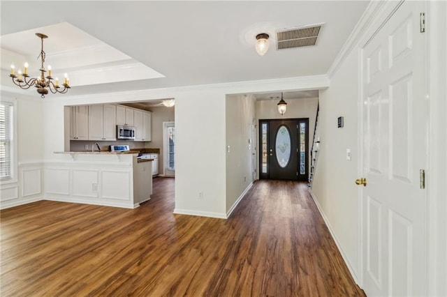 foyer featuring crown molding, dark hardwood / wood-style floors, and a healthy amount of sunlight