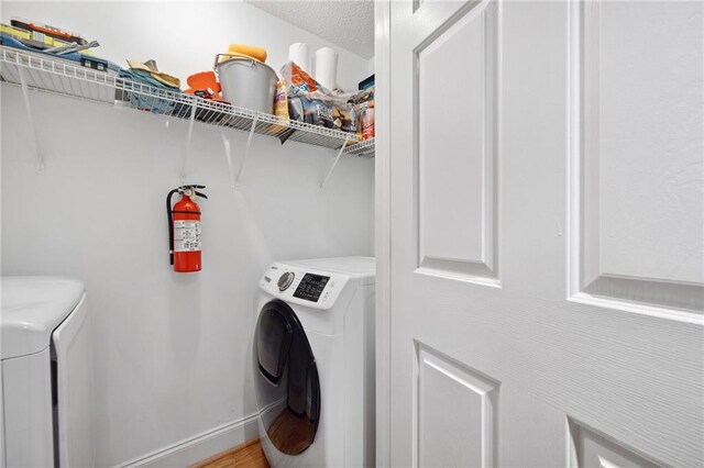 laundry room with baseboards, laundry area, and washer and dryer