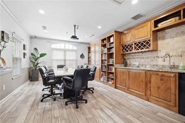 home office with crown molding, visible vents, a sink, and light wood finished floors