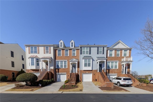 view of property featuring a garage, brick siding, and driveway