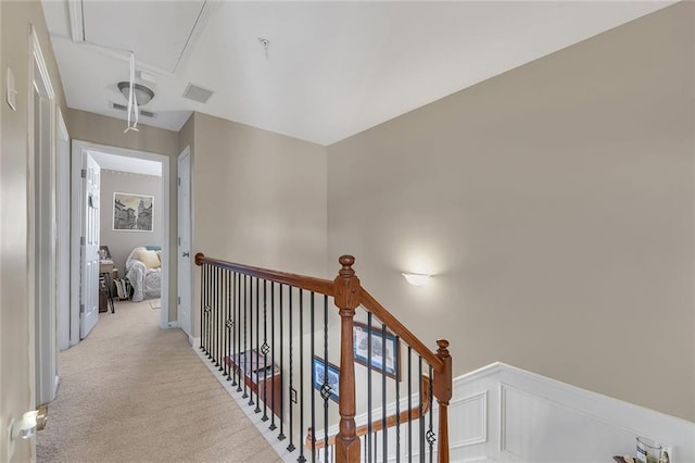 hall featuring visible vents, carpet, an upstairs landing, and attic access