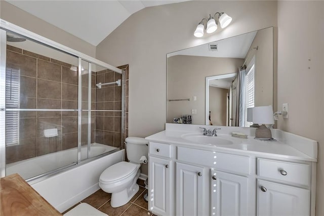 full bath with lofted ceiling, toilet, tile patterned floors, combined bath / shower with glass door, and vanity